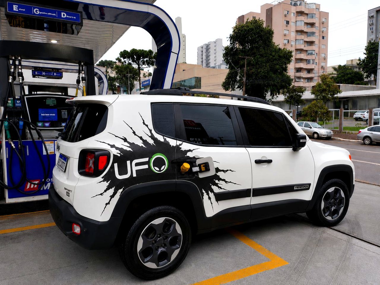 Jeep Renegade branco da frota UFO num posto de combustível